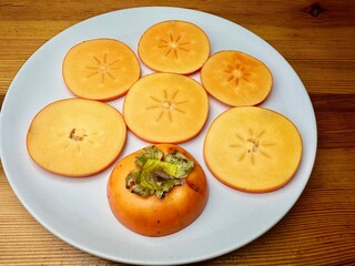 ripe persimmon fruits on a white isolated background persimmon fruits cut into slices