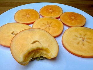 ripe persimmon fruits on a white isolated background persimmon fruits cut into slices