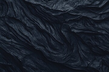 Obraz premium An abstract dark textured surface resembling flowing fabric or rock formations.