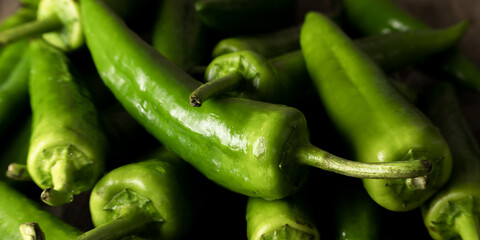 Fresh raw green peppers on table, genuine food ingredients, agricultural concept
