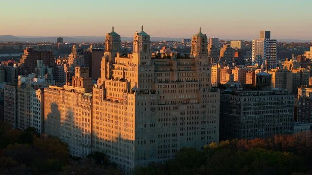 Warm sunlight bathes the elegant facade of the Beresford cooperative apartment building in New York City's Upper West Side neighborhood as the sun sets over Central Park