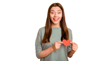 Photo of cheerful cute charming girl being super glad to have received heart shaped present for holiday while isolated with yellow background