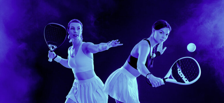 Two Padel tennis players with racket on tournament. Women athletes with paddle racket on court with neon colors. Sport concept. Female doubles - Powered by Adobe