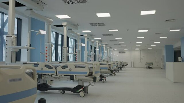 Modern hospital ward with advanced medical equipment, featuring rows of empty hospital beds, bright lights, and a clean environment. Concept of healthcare, technology, and preparedness.