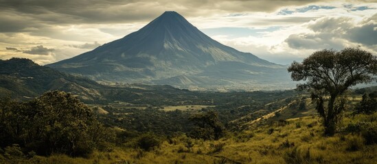 Fototapeta premium Stunning volcanic landscape with towering mountains under dramatic clouds showcasing natural beauty and scenic roadways.