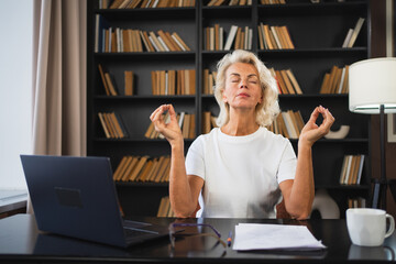 Yoga mindfulness meditation No stress keep calm. Middle aged woman practicing yoga at office. Woman...