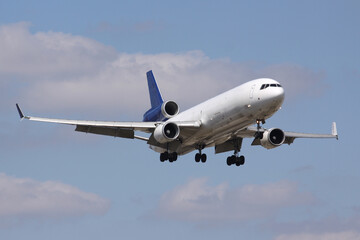 Obraz premium White blue colored Cargo Airplane arriving at Miami International Airport