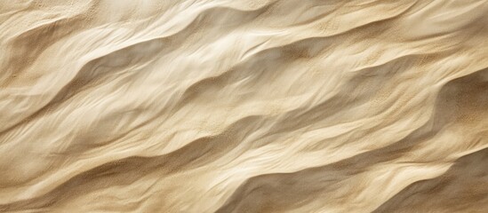 Obraz premium Textured sandy beach surface viewed from above showcasing natural patterns and colors in warm tones for backgrounds and designs.