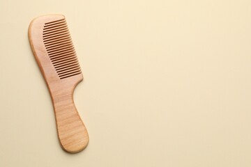 One wooden hair comb on beige background, top view. Space for text