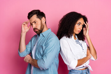 Casual young couple posing against a pink background, expressing thoughts