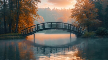 Naklejka premium Misty sunrise over wooden bridge reflecting in calm lake, autumn foliage.