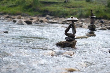 Two figures made of river stones in the middle of the stream.