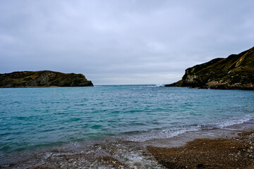 Lulworth Cove and beach view at winter day. Lulworth Cove bay, beach and cliffs view . The Jurassic Coast is a World Heritage Site on the English Channel coast of southern England. Dorset, UK. public 