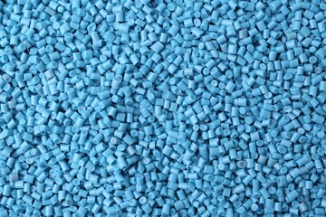 Pile of light blue plastic granules as background, top view
