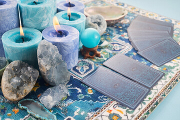 Mystical Card Reading Setup. Blue candles, crystals, and tarot cards on a patterned cloth.