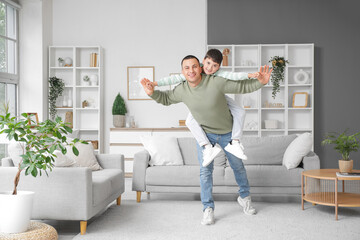 Fototapeta premium Cute little boy with his father having fun at home