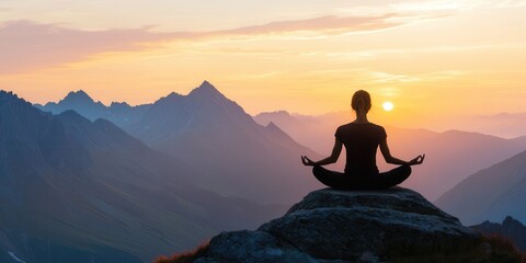 Obraz premium Mindful living and wellness meditation concept. Silhouette of a person meditating at sunset in a mountainous landscape.