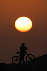 Obraz premium Silhouette of a biker during sunset at Bahrain