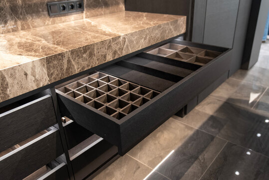 Wooden drawer with organized compartments in a modern kitchen