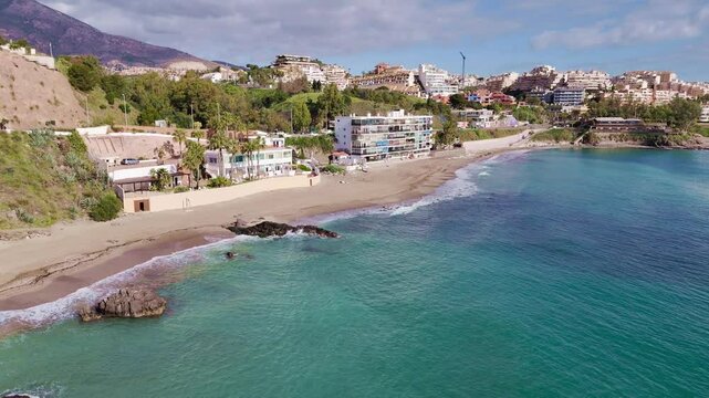 Drone flight along Playa Bonita with views of ramshackle beachside appartment block.