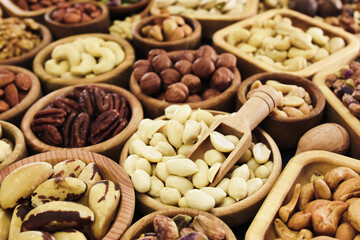 Colorful mix of various nuts: peanut and cashew, hazelnut and almond, pine nuts and walnut; healthy diet snack; vegan food background, selective focus, shallow focus