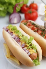 Tasty hot dogs served on white table, closeup