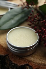 Natural solid perfume and skimmia plant on wood, closeup