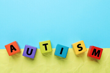 Obraz premium Word Autism made of colorful cubes on color background, top view. Space for text