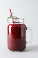 Fresh beetroot smoothie in mason jar on light background, closeup
