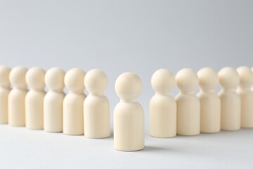 Competition concept. One human figure ahead of others on light background, closeup
