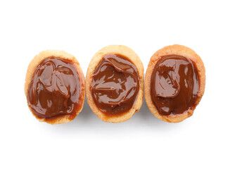 Halves of sweet walnut shaped cookies with boiled condensed milk on white background