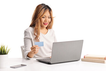 Asian woman shopping online with a laptop computer and credit card