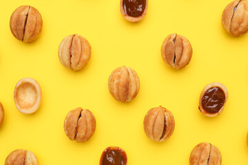 Sweet walnut shaped cookies with boiled condensed milk on yellow background