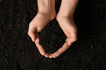 Female hands with black soil, closeup