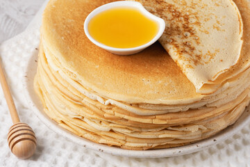 Stack of traditional russian pancakes blini on a white table. Homemade russian thin pancakes blini....