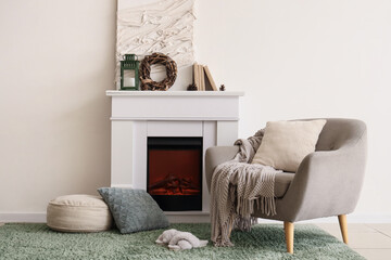 Interior of living room with fireplace, armchair and Christmas wreath