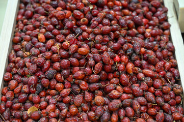 Rose hips in a pile for sale at market. Ripe dried rose hips for tea.