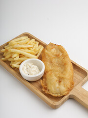 fish and chips with tartar sauce on black plate