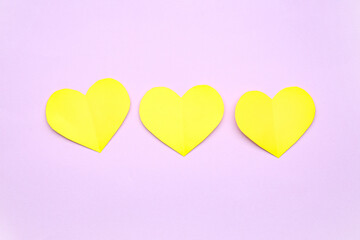 Yellow paper hearts on lilac background. Valentine's Day celebration