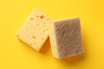 Soft sponge on yellow background, top view