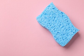 Light blue sponge on pink background, top view. Space for text