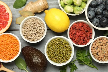 Superfood. Different healthy food products on grey wooden table, flat lay