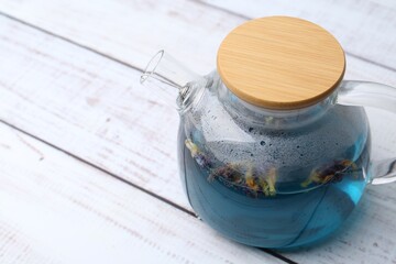 Delicious butterfly pea flower tea on wooden table, closeup. Space for text