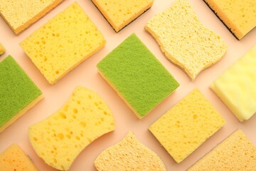 Many colorful sponges on beige background, flat lay