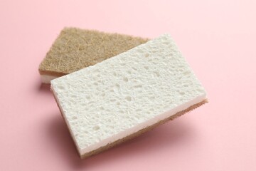 Two sponges on pink background, closeup view