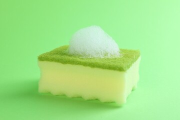 One sponge with foam on green background, closeup