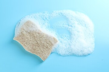 One sponge with foam on light blue background, top view
