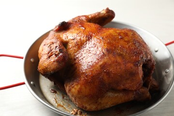 Delicious baked turkey in baking dish on light table, closeup