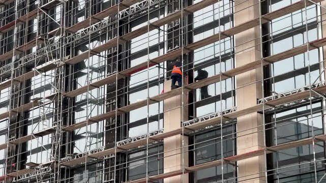 Construction of a multi-storey building facade work builder are assembling windows construction site