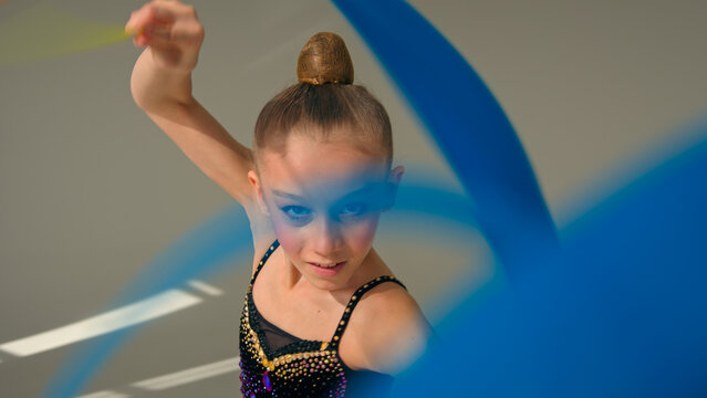 Little girl child kid daughter Caucasian schoolgirl young athlete teenager sport gymnast artistic female ballet dancer sportswoman perform swirling spinning gymnastic tape dance studio choreography